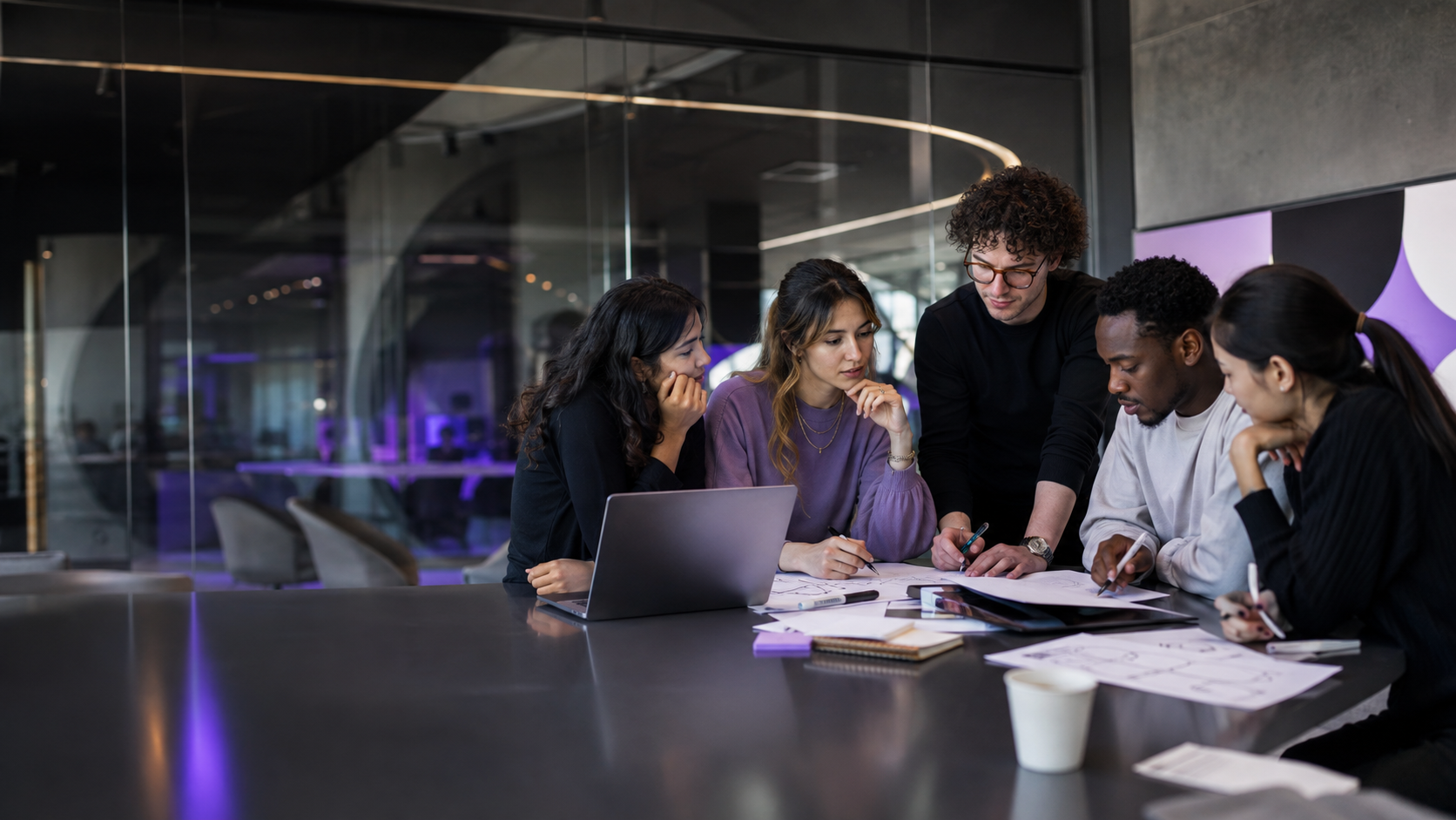 Students collaborating with a mentor in a modern innovation studio